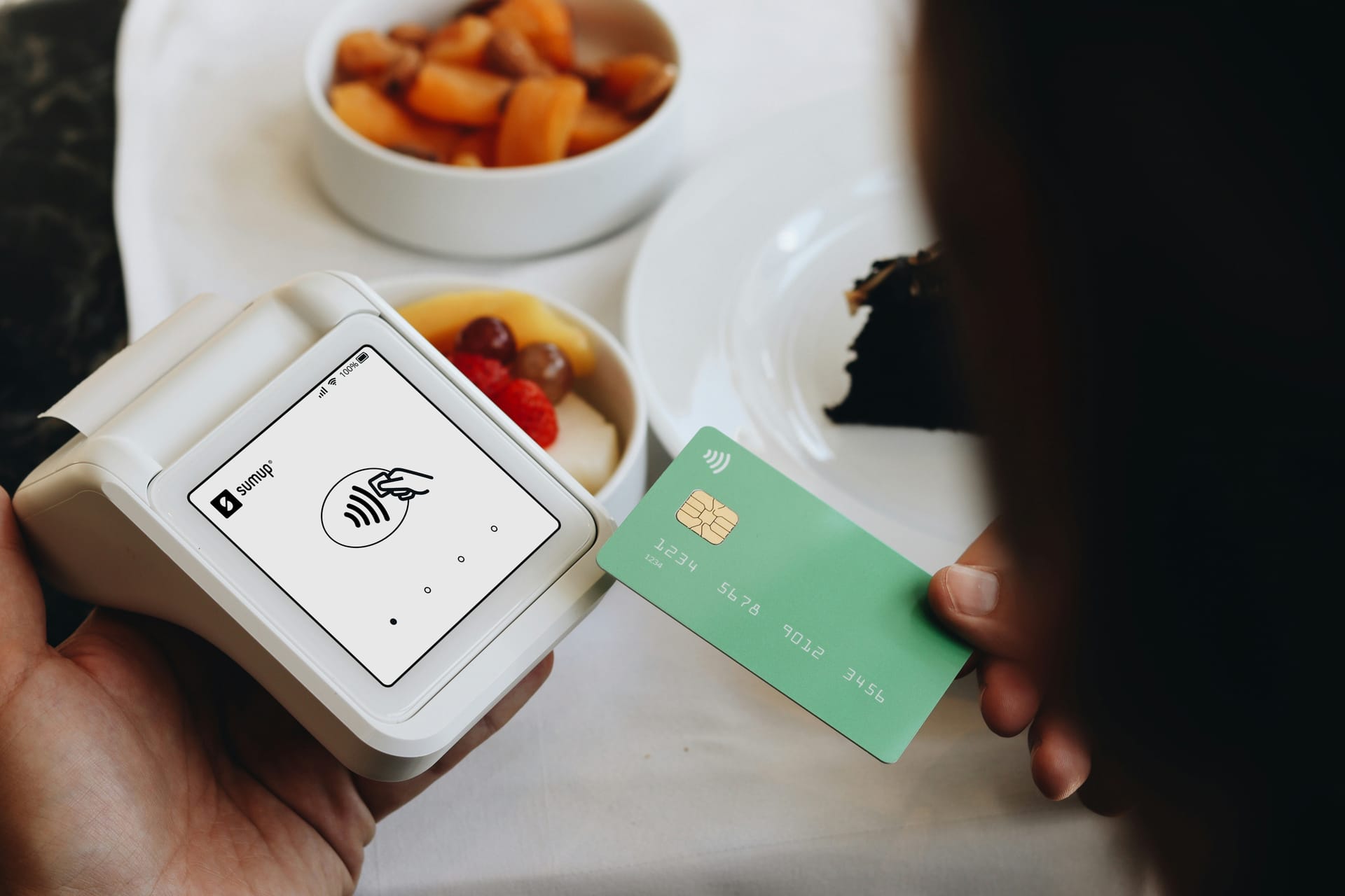 A contactless payment terminal being used in a café