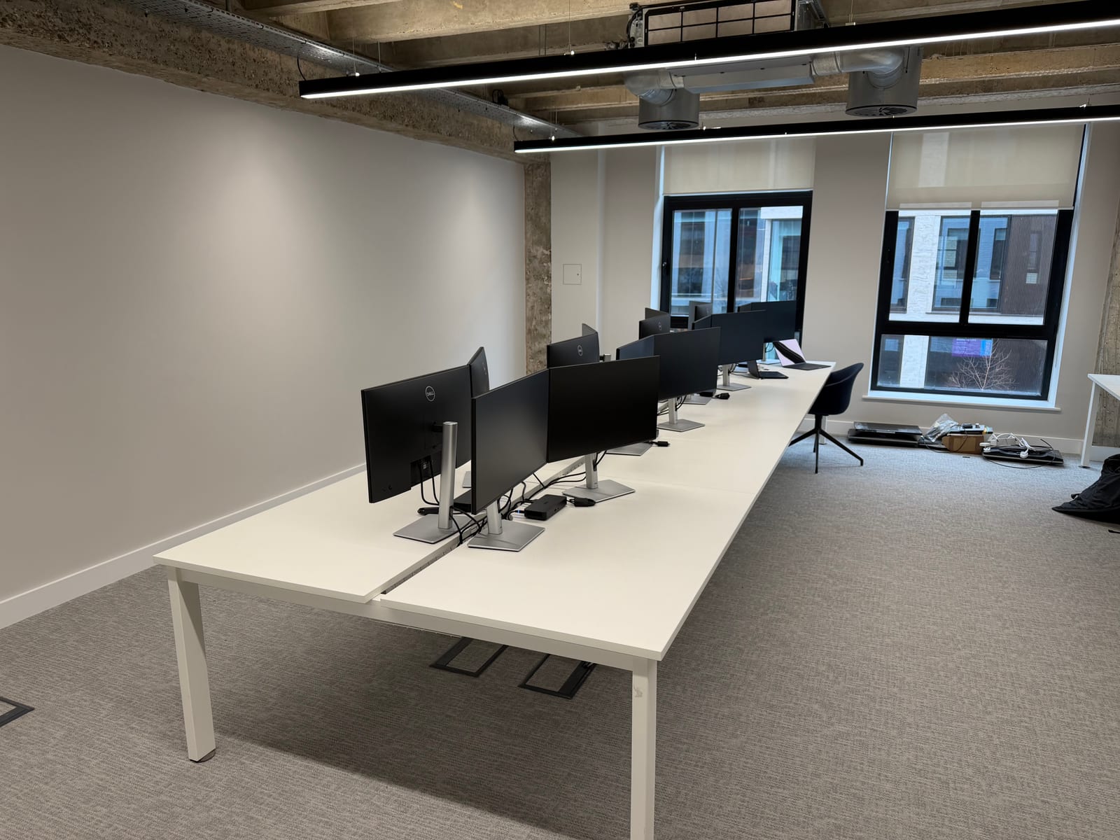 A row of dual-monitor workstations during the office setup.