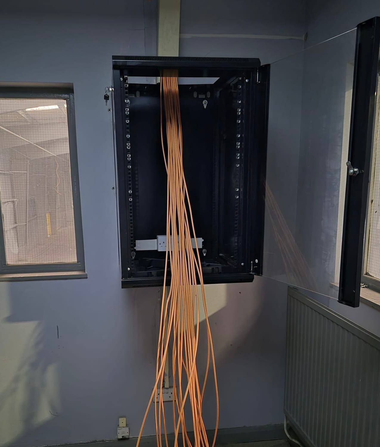 Cable runs brought into the cabinet before termination.