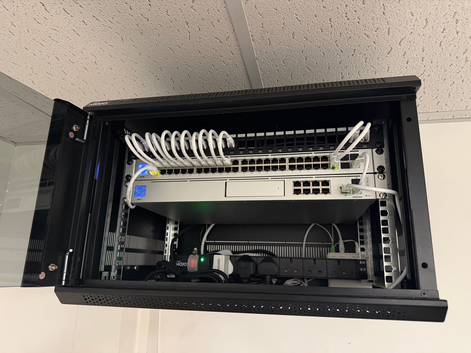 The fitted cabinet with the UniFi gateway, switch and patch connections.